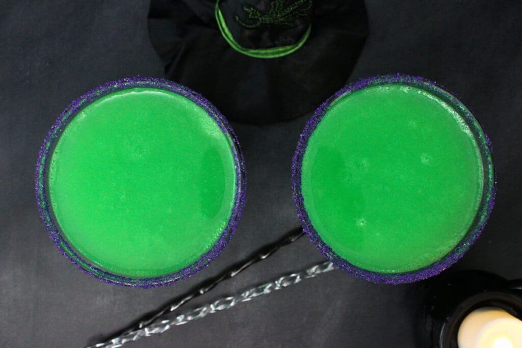 overhead view of two green wicked with cocktails with stirrers