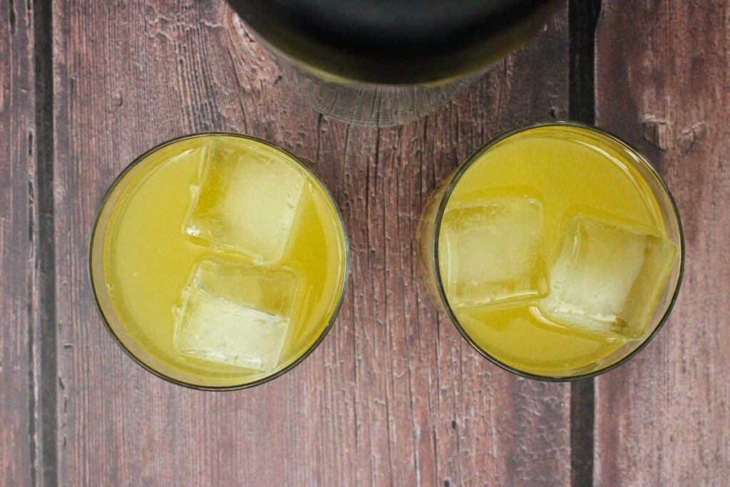 shake and strain cranberry orange whiskey sour into glasses