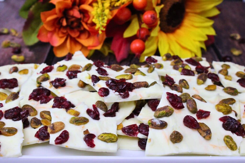white chocolate cranberry bark topped with pistachios spread across a platter