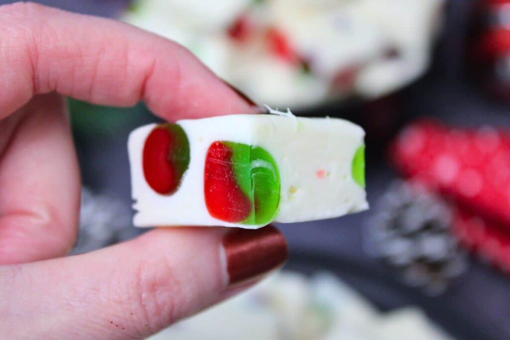 holding up a square of marshmallow nougat to show the candy inside