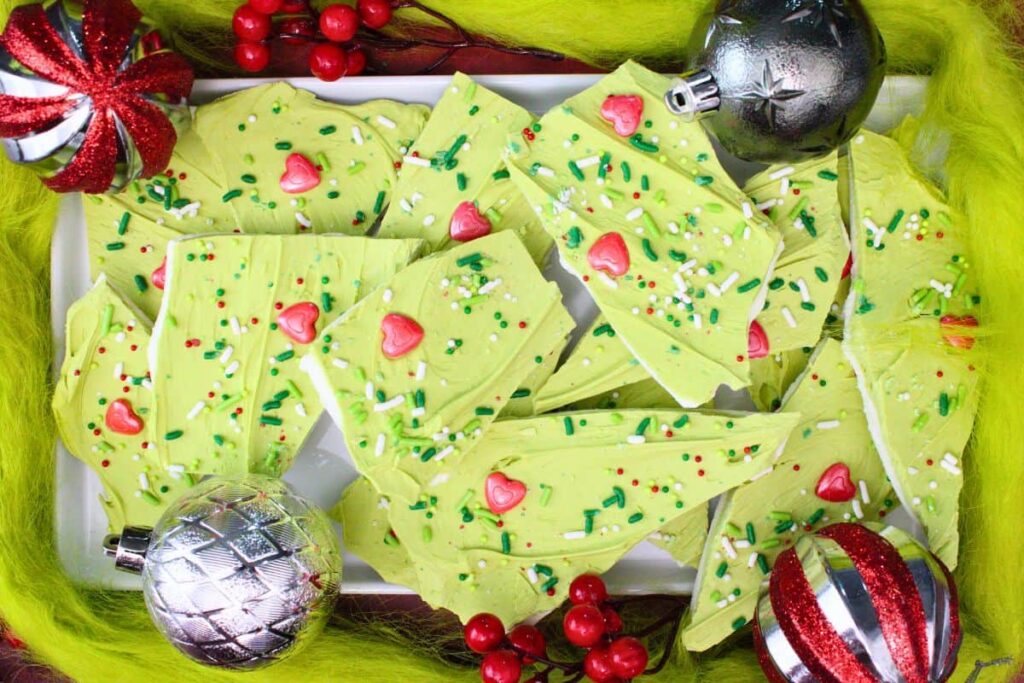 overhead view of grinch bark pieces on a plate with christmas ornaments