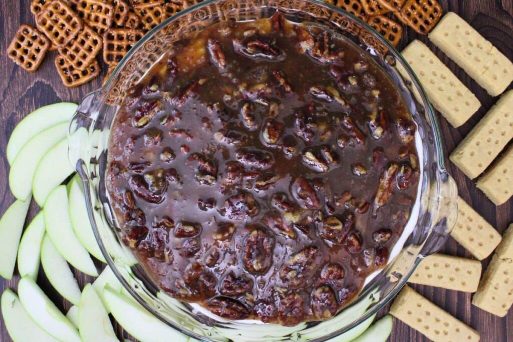 overhead view of pecan pie dip surrounded by apple, pretzels, and shortbread cookies