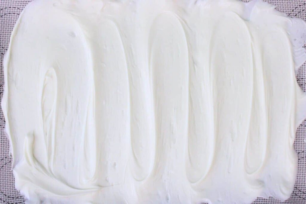 pour melted white chocolate on a parchment lined baking sheet