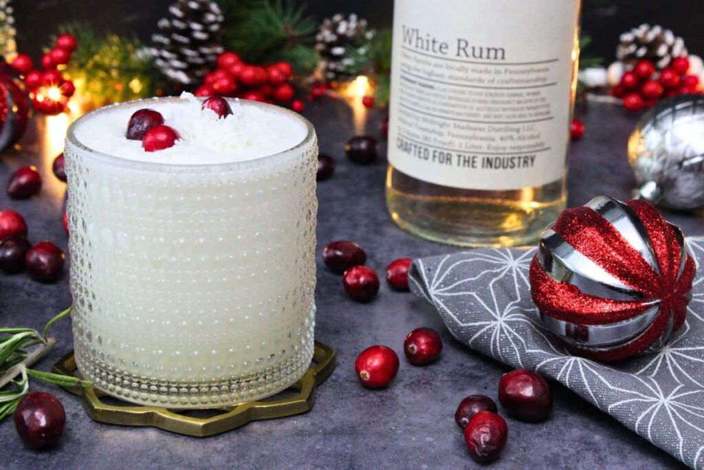 white christmas punch drink in a holiday scene next to bottle of rum