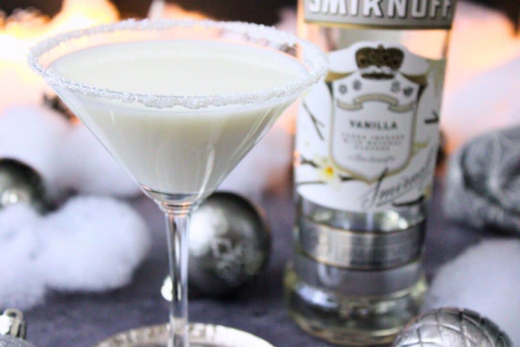 closeup of white christmas martini in front of vodka bottle