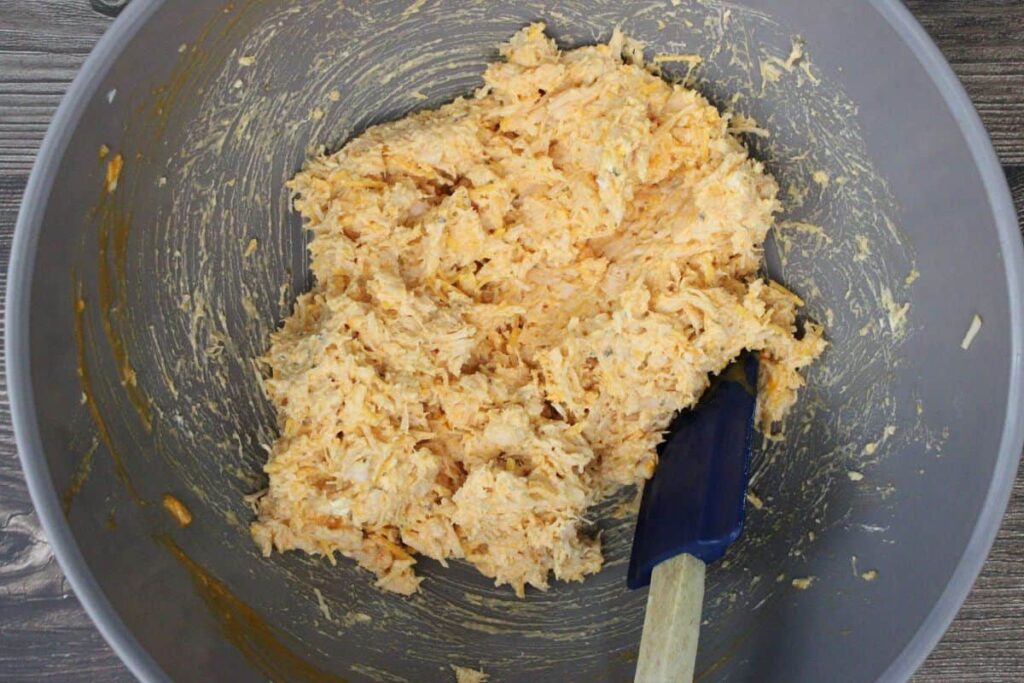combine chicken, buffalo sauce, ranch, garlic powder, cream cheese, and cheddar cheese