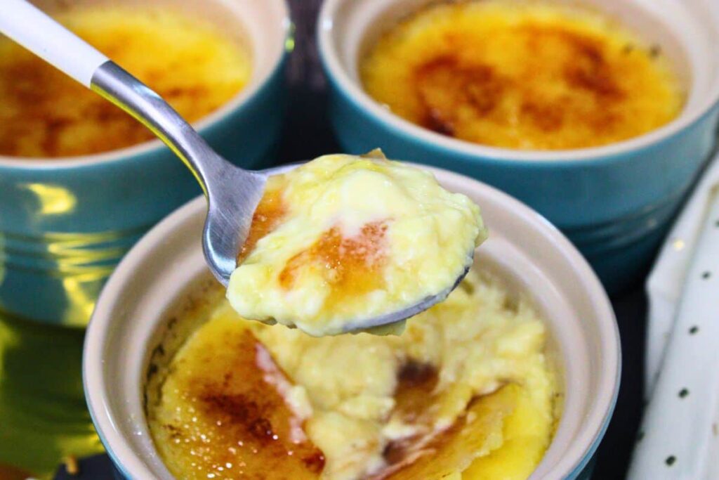 holding up a spoonful of creme brulee