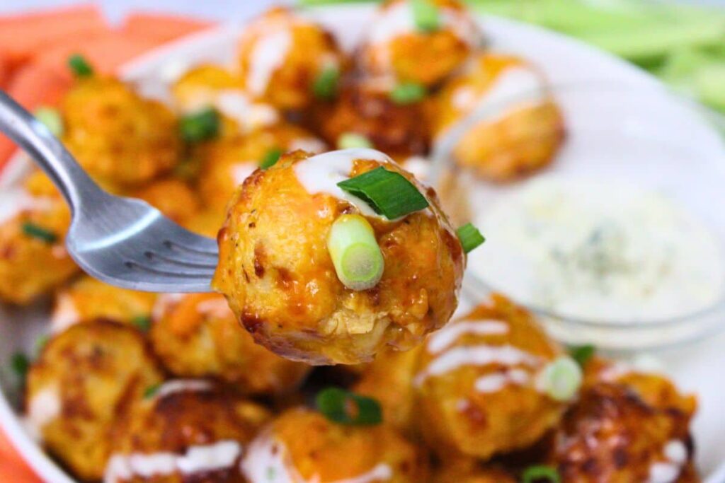 holding up an air fryer buffalo chicken meatball on a fork