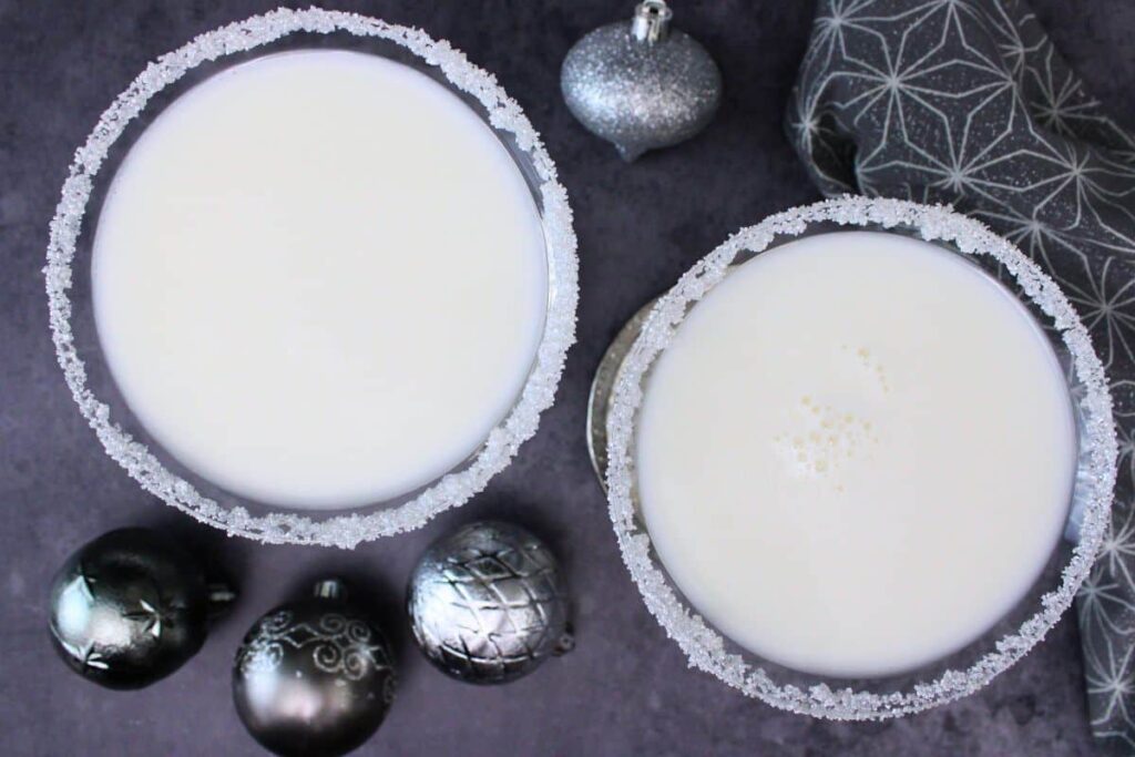 overhead view of two white christmas martinis and silver ornaments