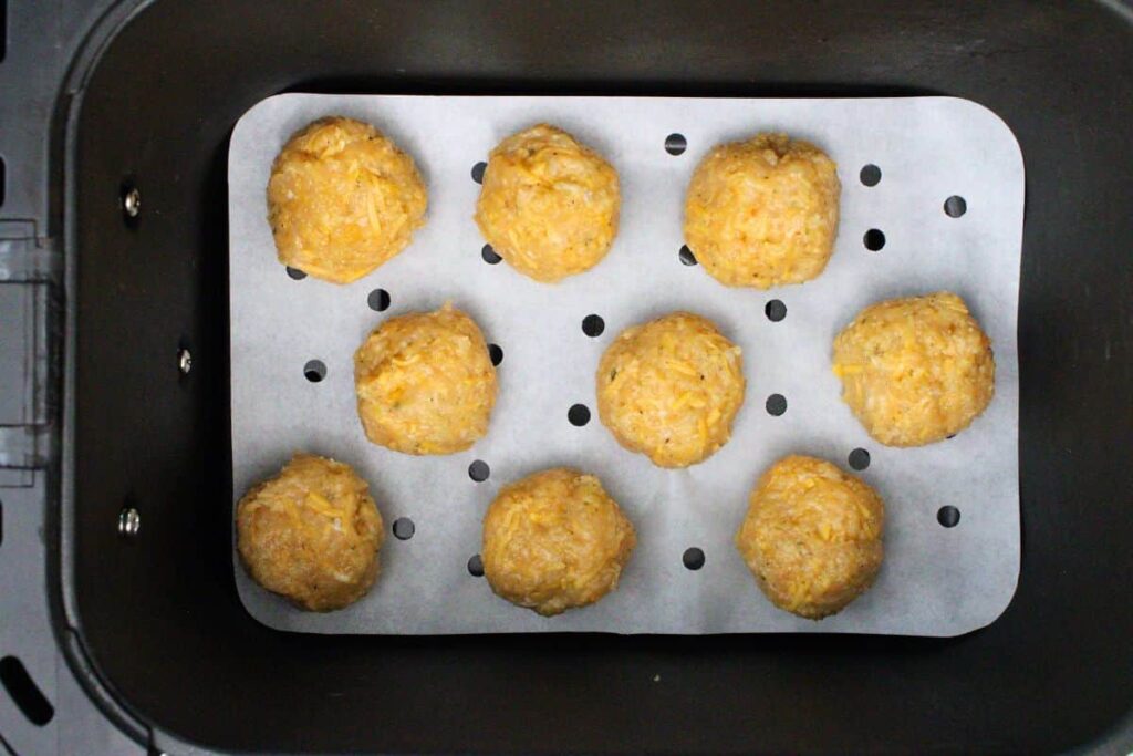 place uncooked chicken meatballs in air fryer basket
