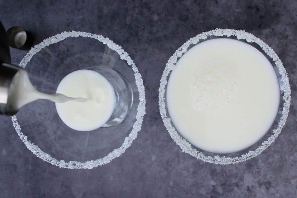 strain white christmas martini into prepared glasses