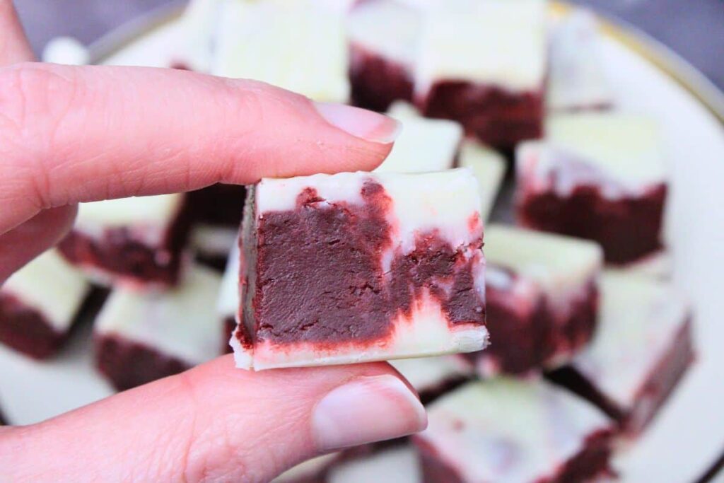 holding up a square of red velvet fudge
