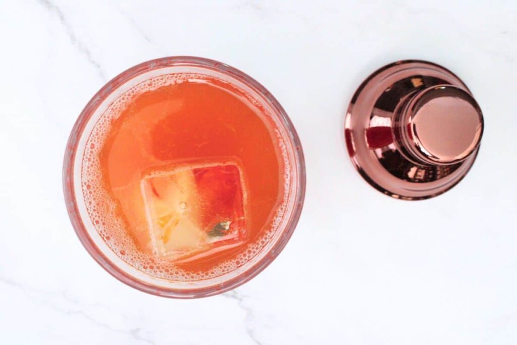 add whiskey and ice cubes to muddled strawberries