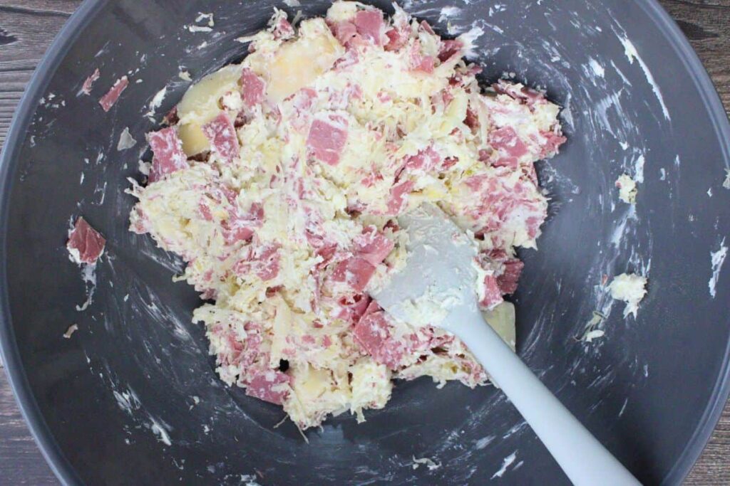 combine corned beef, cream cheese, swiss cheese, and sauerkraut in a large bowl