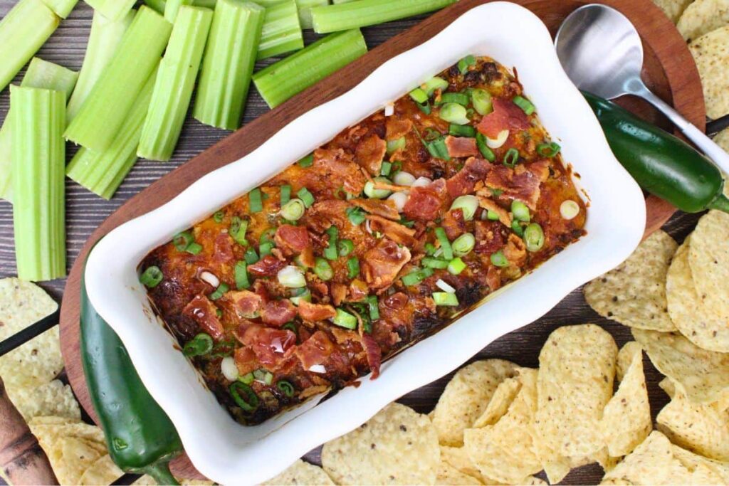 overhead view of air fryer jalapeno dip surrounded by celery, tortilla chips, and a jalapeno