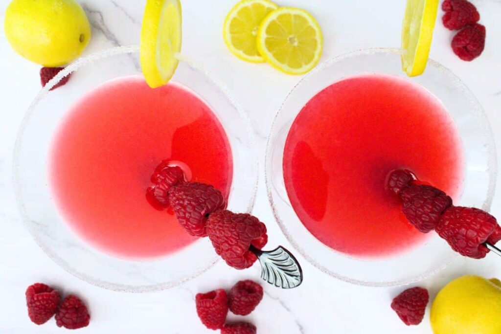 overhead view of two raspberry lemon drop martinis garnished with raspberry skewers