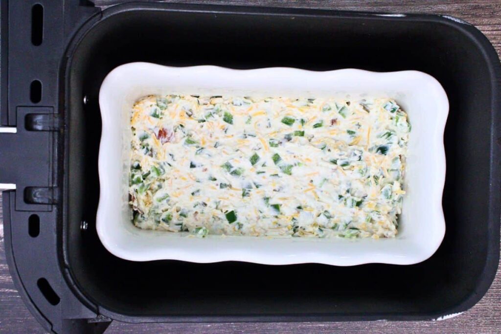 place casserole dish with jalapeno popper dip in air fryer basket