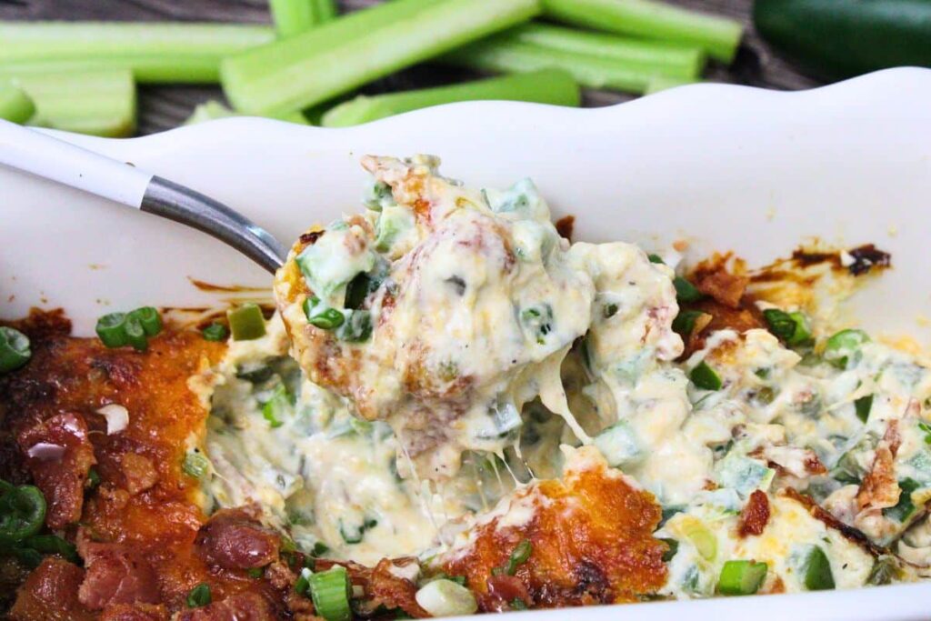 pulling out a spoonful of cheesy jalapeno popper dip