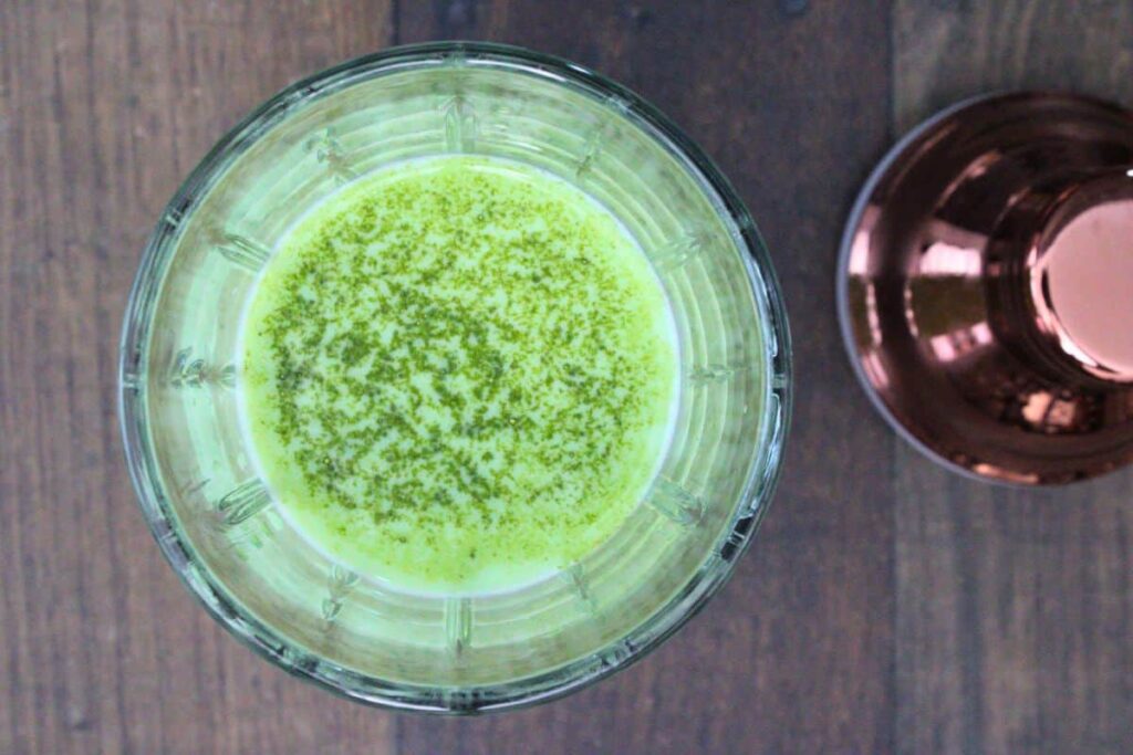 add infused vodka to cocktail shaker with baileys, half and half, matcha powder, and ice cubes