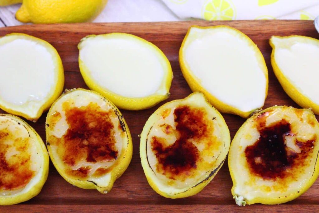 fresh lemon posset laid across a wooden serving tray with the bottom half being bruleed