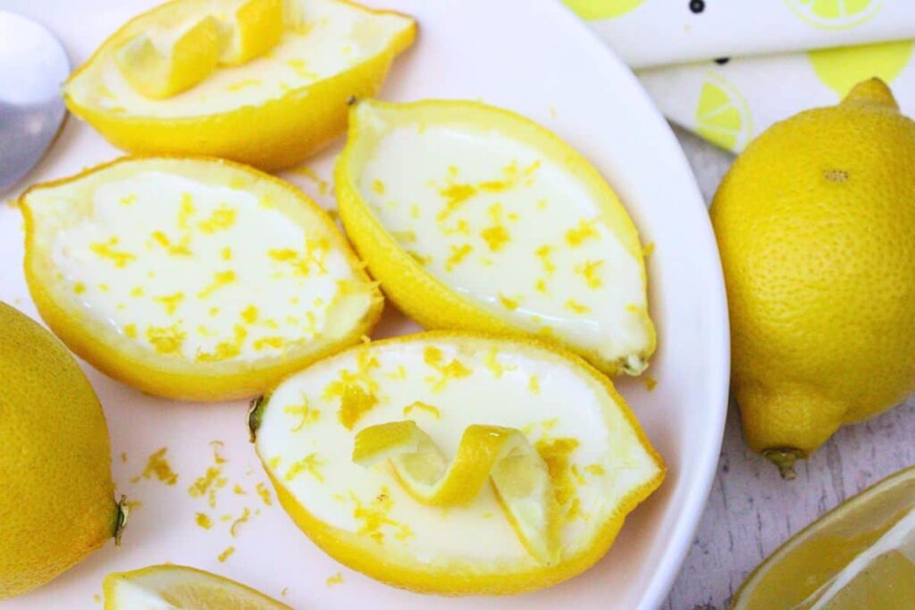 lemon posset on a white plate with extra lemon zest on top