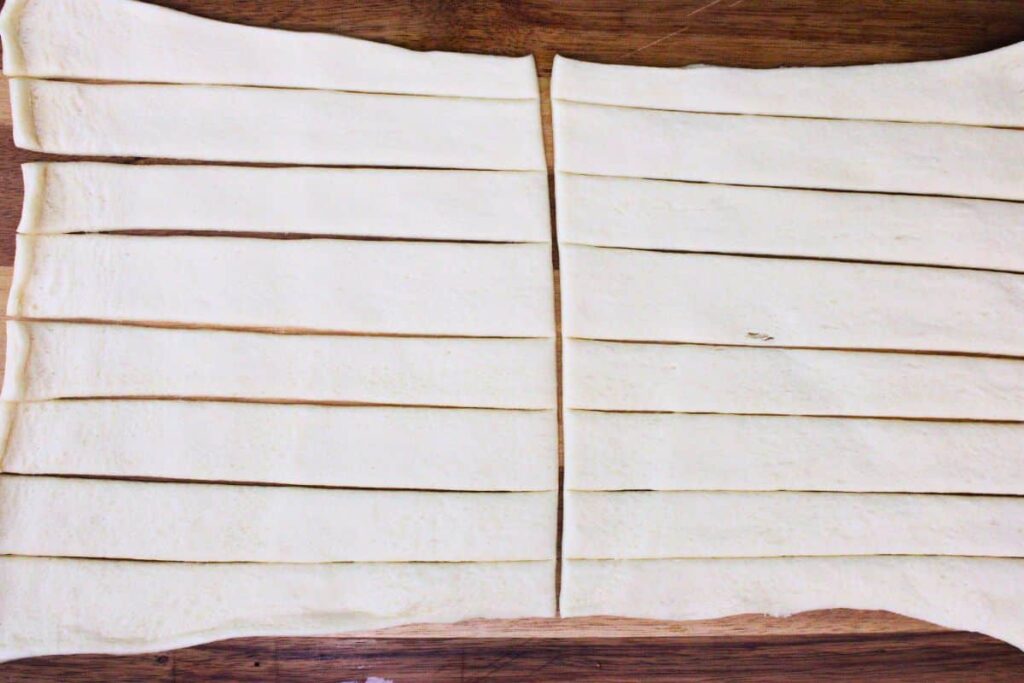 roll out crescent dough and cut into even strips