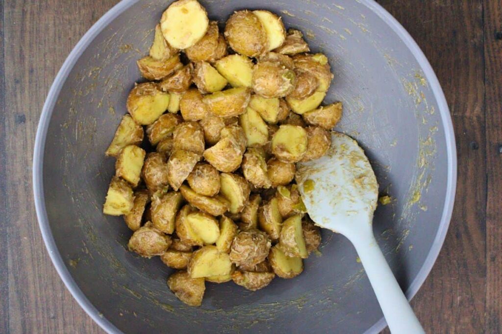 toss potatoes with melted butter, lime juice, green chiles, salt, and gunpowder seasoning