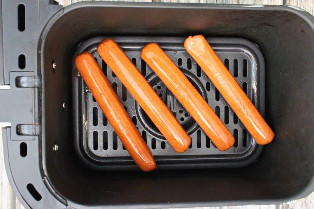 add hot dogs to air fryer basket leaving space in between