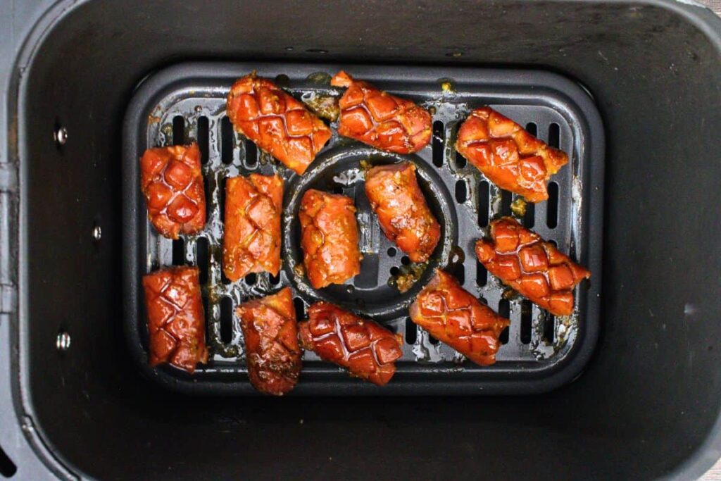 place bbq basted and cut pinecone hot dogs back in air fryer basket