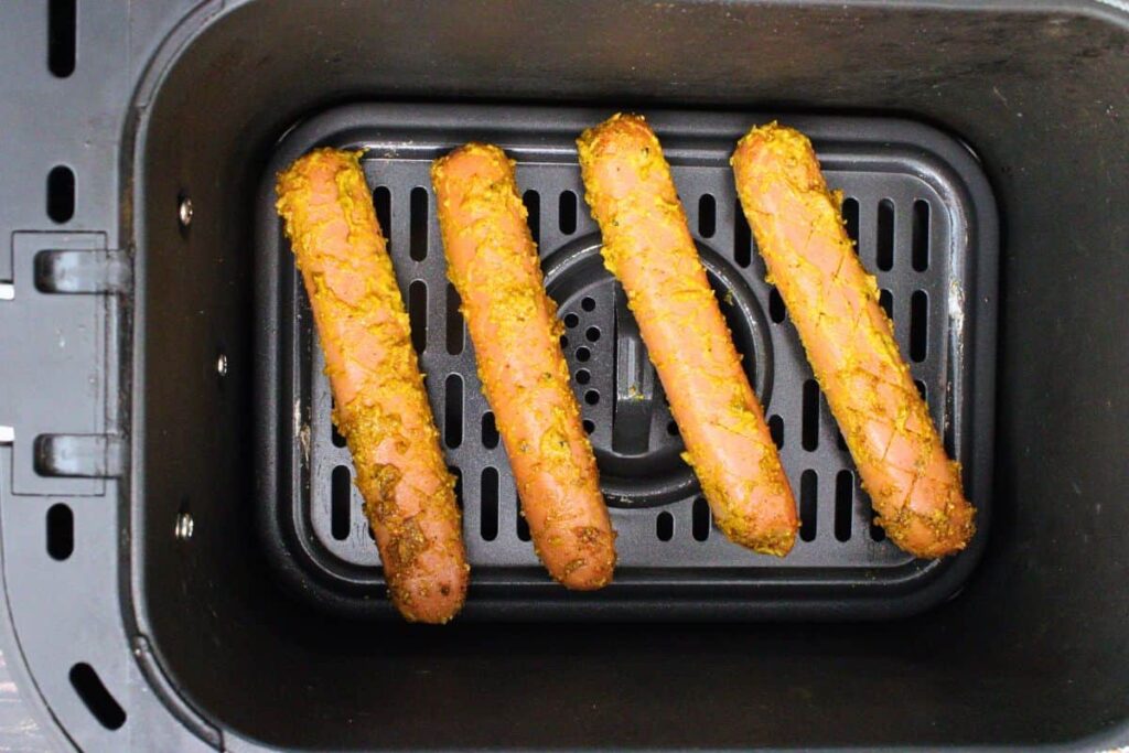 place seasoned and cut hot dogs in air fryer basket