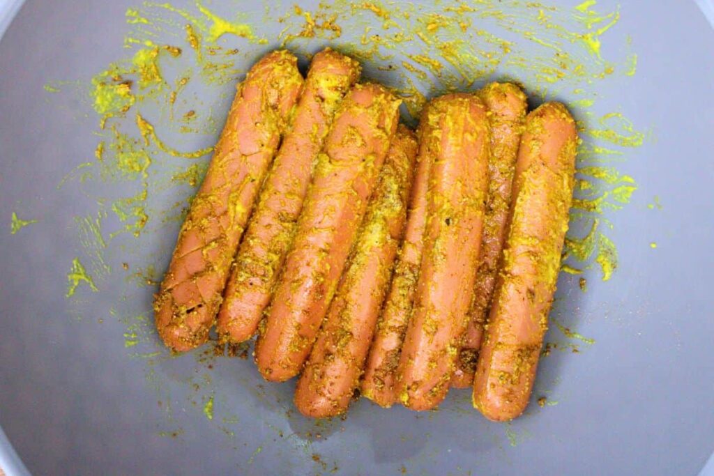 rub hot dogs with mustard and bbq seasoning