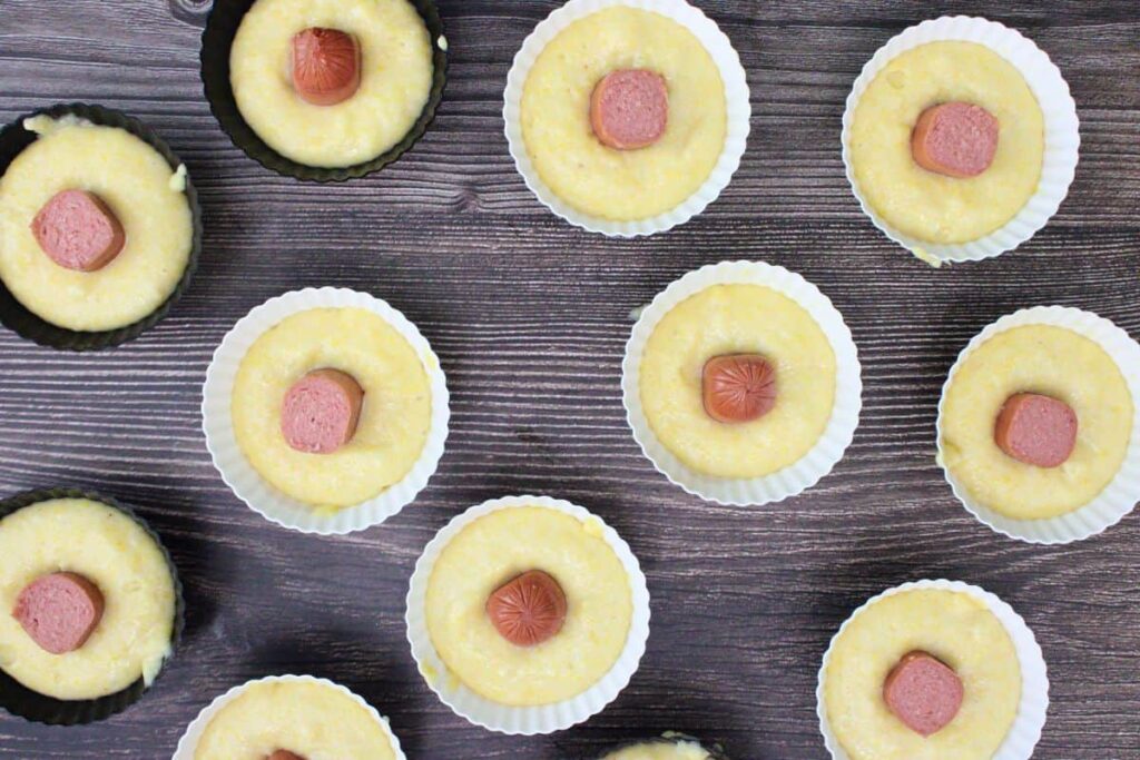 press hot dog piece into the center of each muffin cup