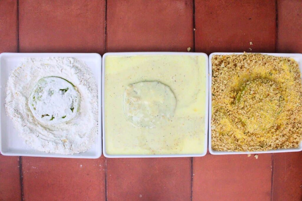 dredge each green tomato slice in flour, egg, and breadcrumbs