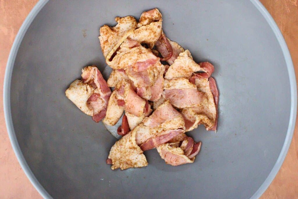 in a mixing bowl combine cinnamon and sugar then coat bacon strips