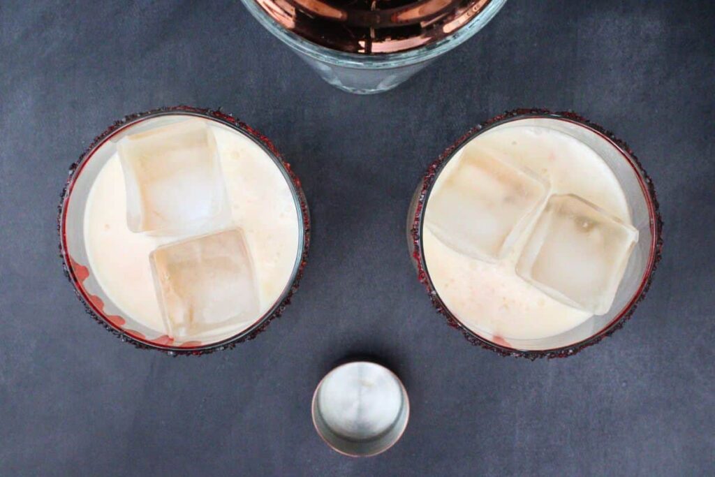 shake and strain frothy bloody tequila sunset into prepared glasses