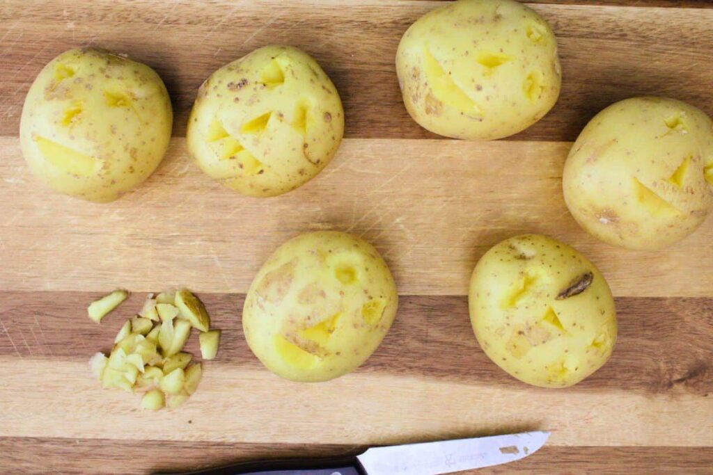 use a knife to carve faces into the potatoes