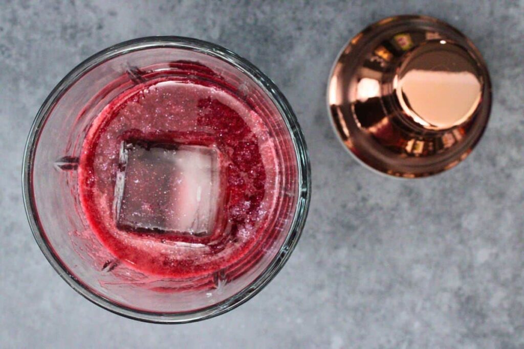 add blackberry puree to cocktail shaker with tequila, cassis liqueur, and luster dust