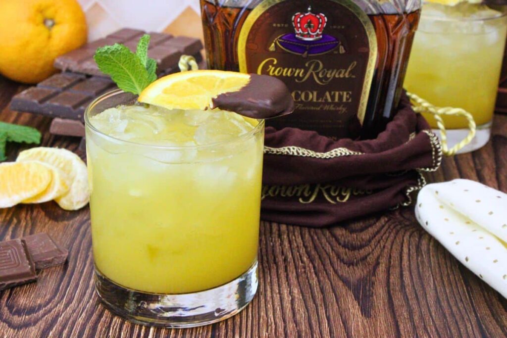 chocolate orange smash drink garnished with mint and chocolate covered orange next to chocolate crown royal bottle