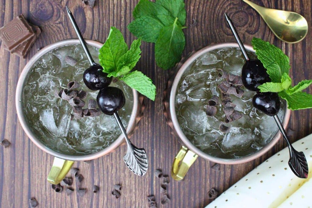 overhead view of two chocolate mules garnished with mint luxardo cherry and chocolate curls