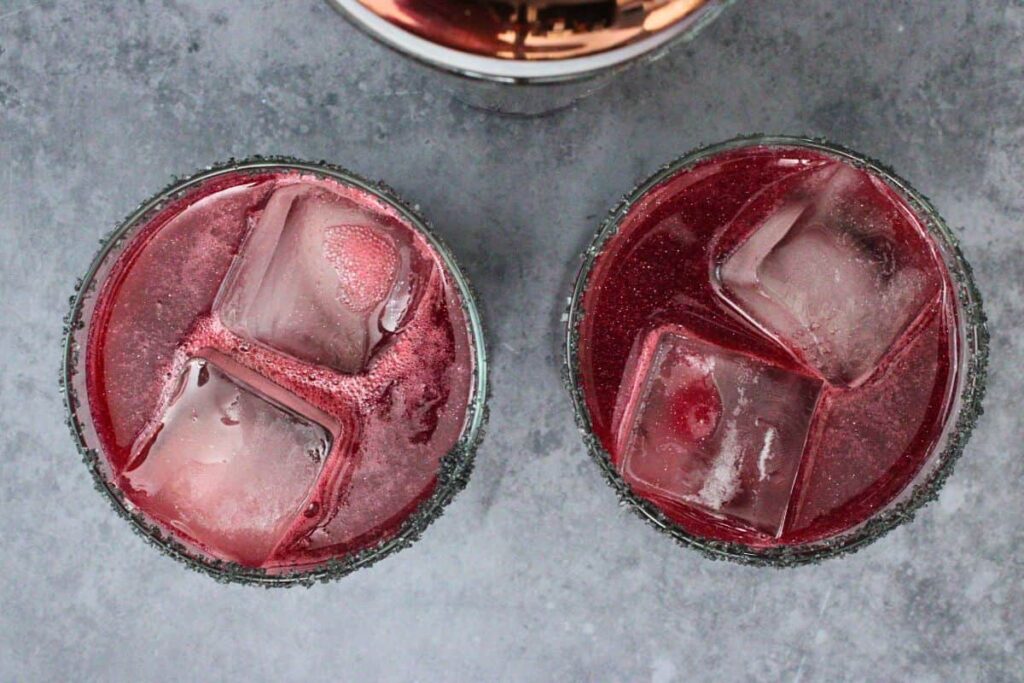 shake and strain black magic margaritas into prepared glasses