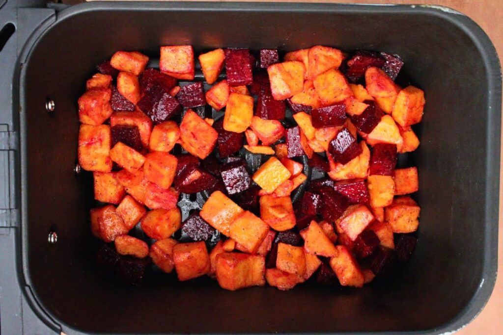 spread seasoned beets and sweet potatoes across preheated air fryer basket