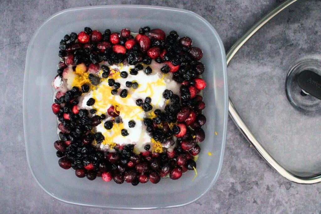 add cranberries, sugar, blueberries, orange juice, zest, and liquer to anyday microwave safe glass dish