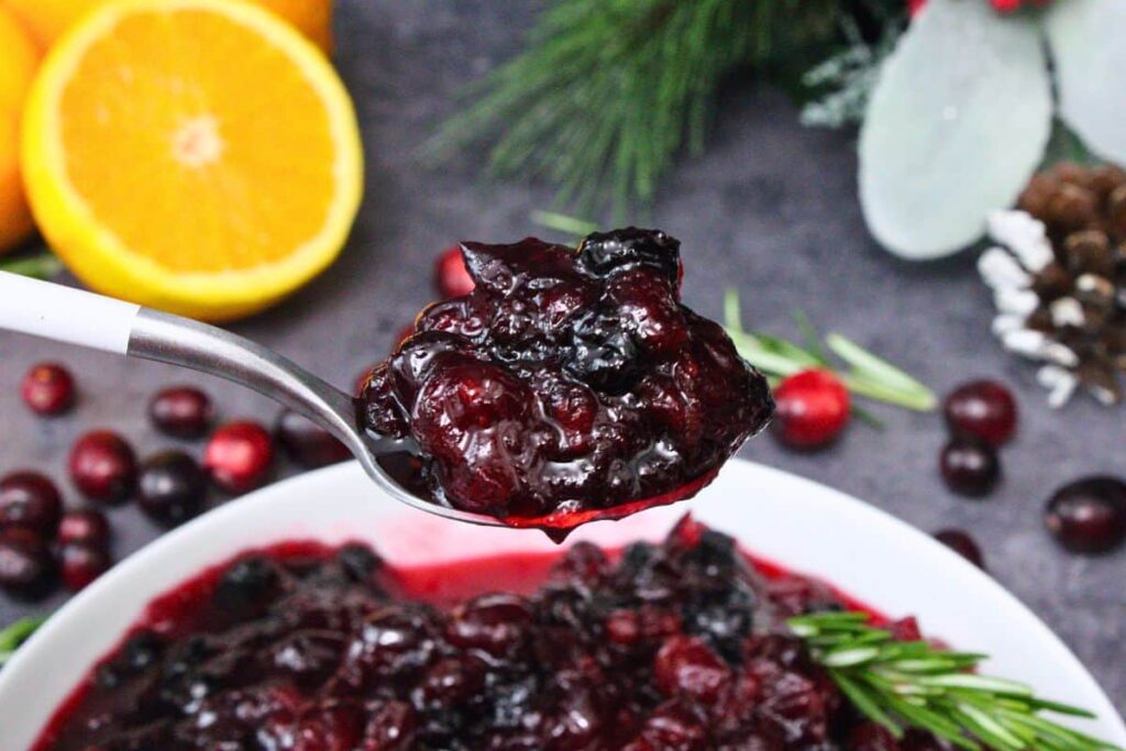 holding up a spoonful of microwave cranberry sauce showing the juicy deep red colors