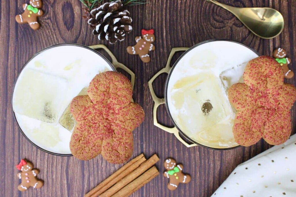 overhead view of two gingerbread white russian drinks garnished with gingerbread man cookie on a wooden counter