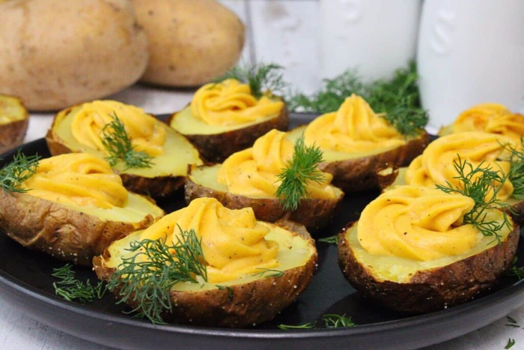 black plate of deviled potatoes garnished with dill