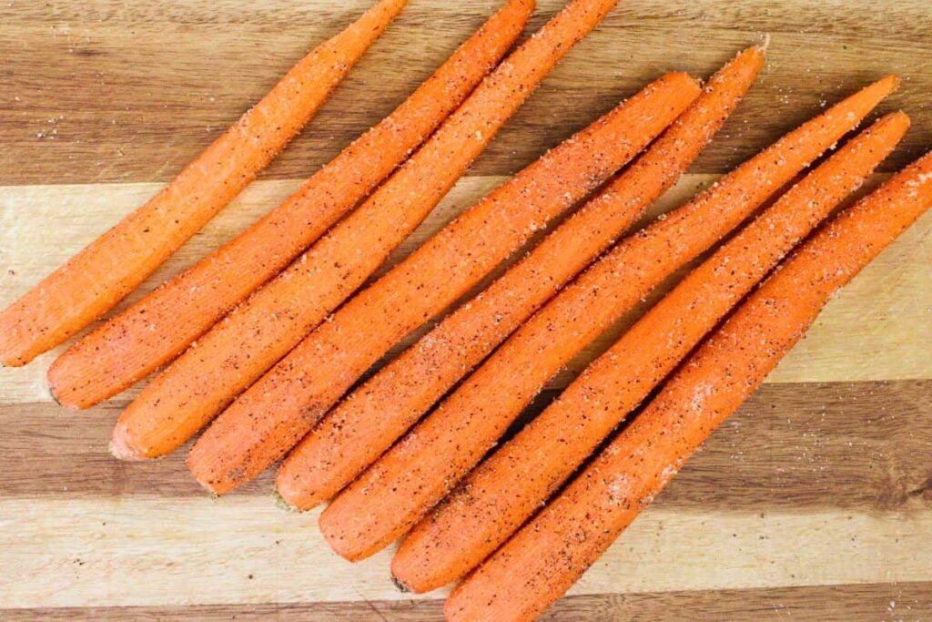 toss peeled carrots with salt, pepper, and garlic powder