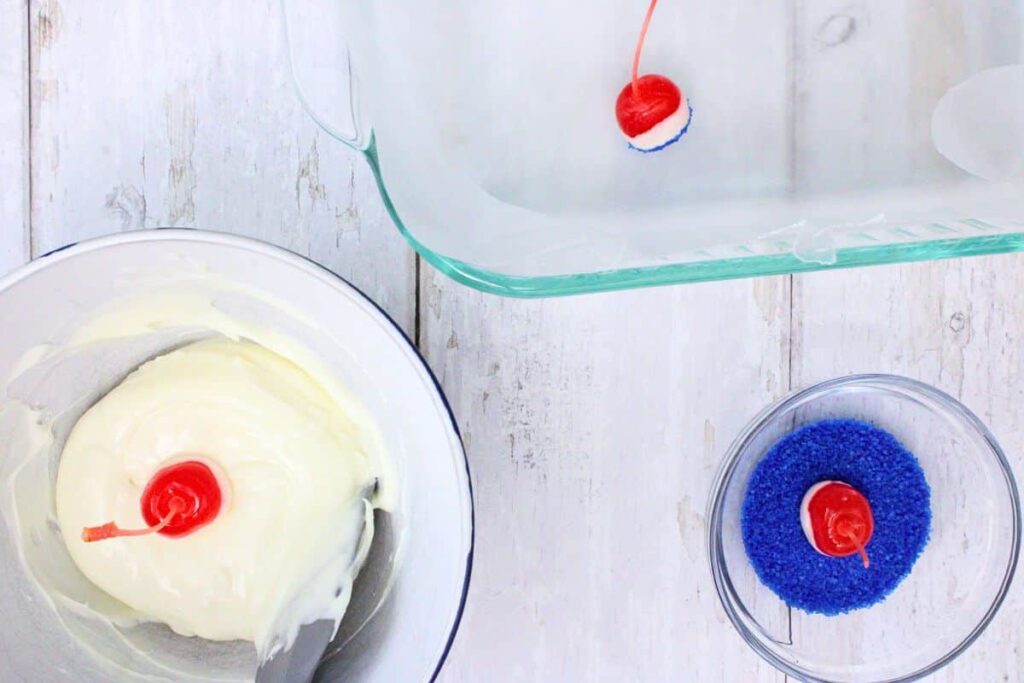 dip each cherry in the melted white chocolate and then the sanding sugar