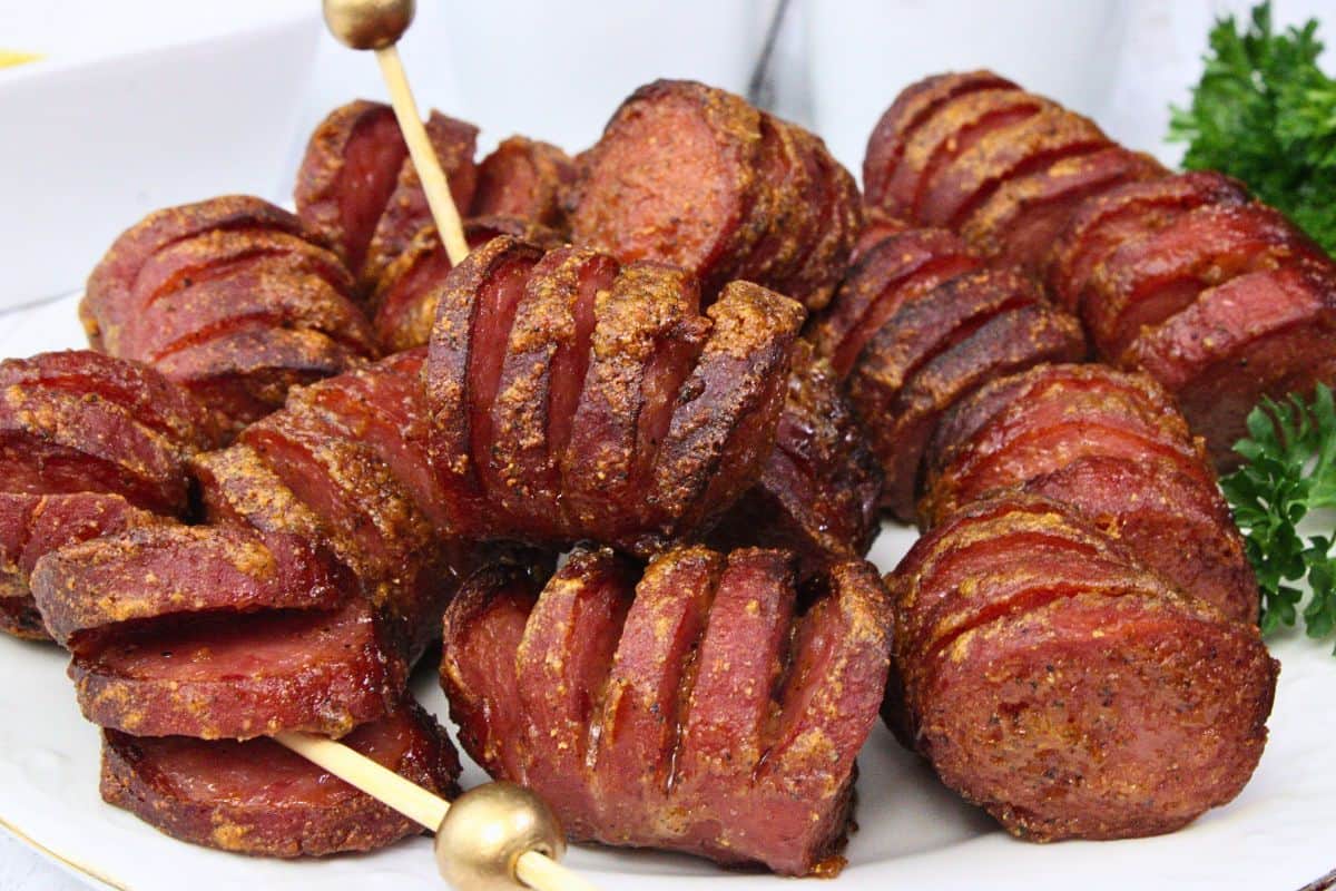 closeup view of a plate filled with hasselback kielbasa bites showing off the glaze