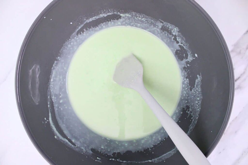 add pistachio pudding mix milk and amaretto to a large mixing bowl