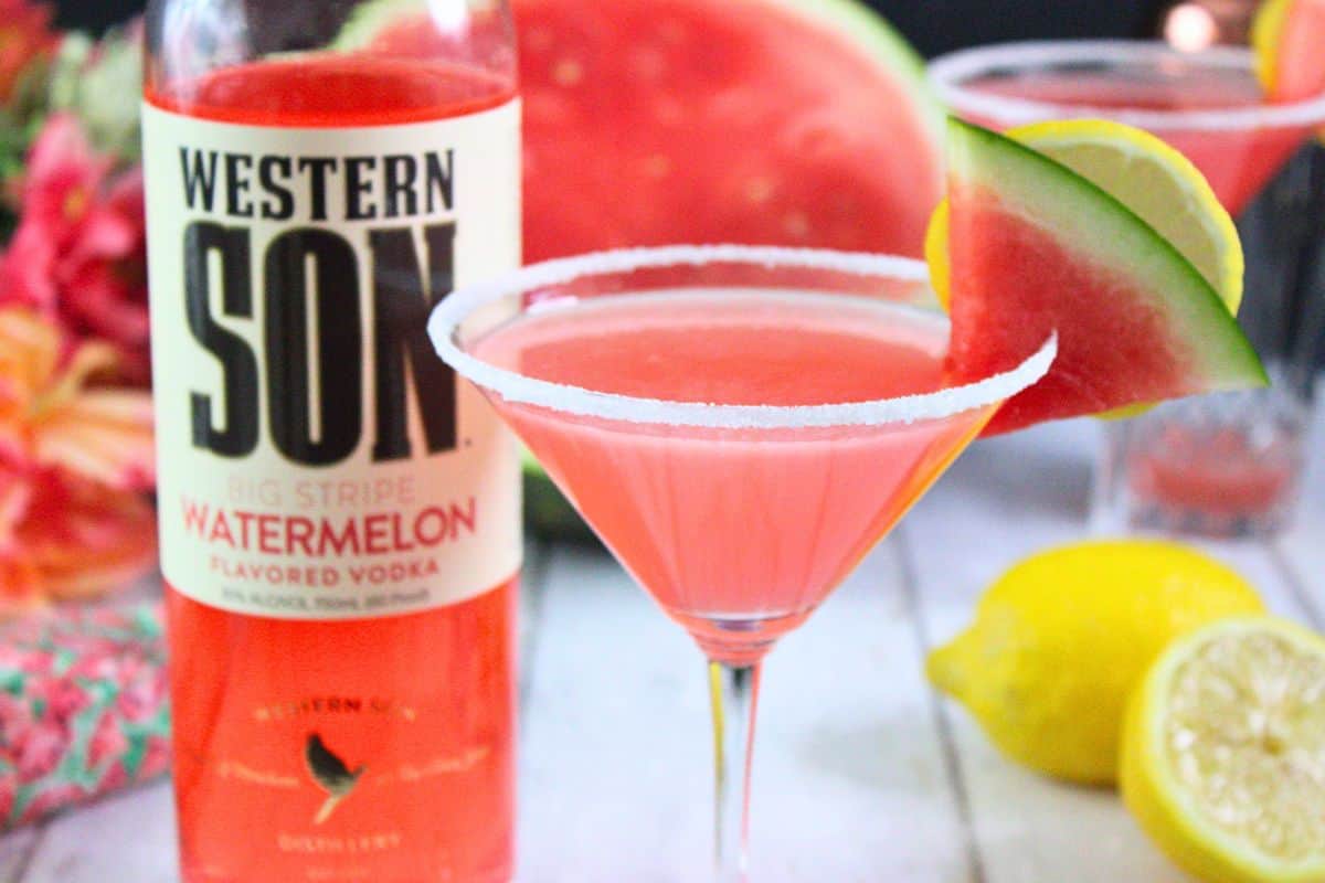 closeup view of watermelon lemon drop with sugar rim martini glass garnished with fresh fruit